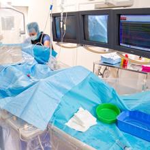 Photo d'une salle d'imagerie médicale utilisée en cardiologie présentant un médecin cardiologue et son patient